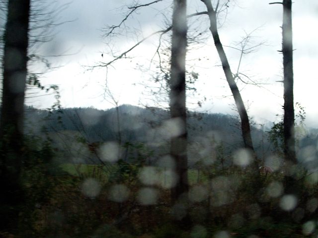 Trees and hills blurred by raindrops